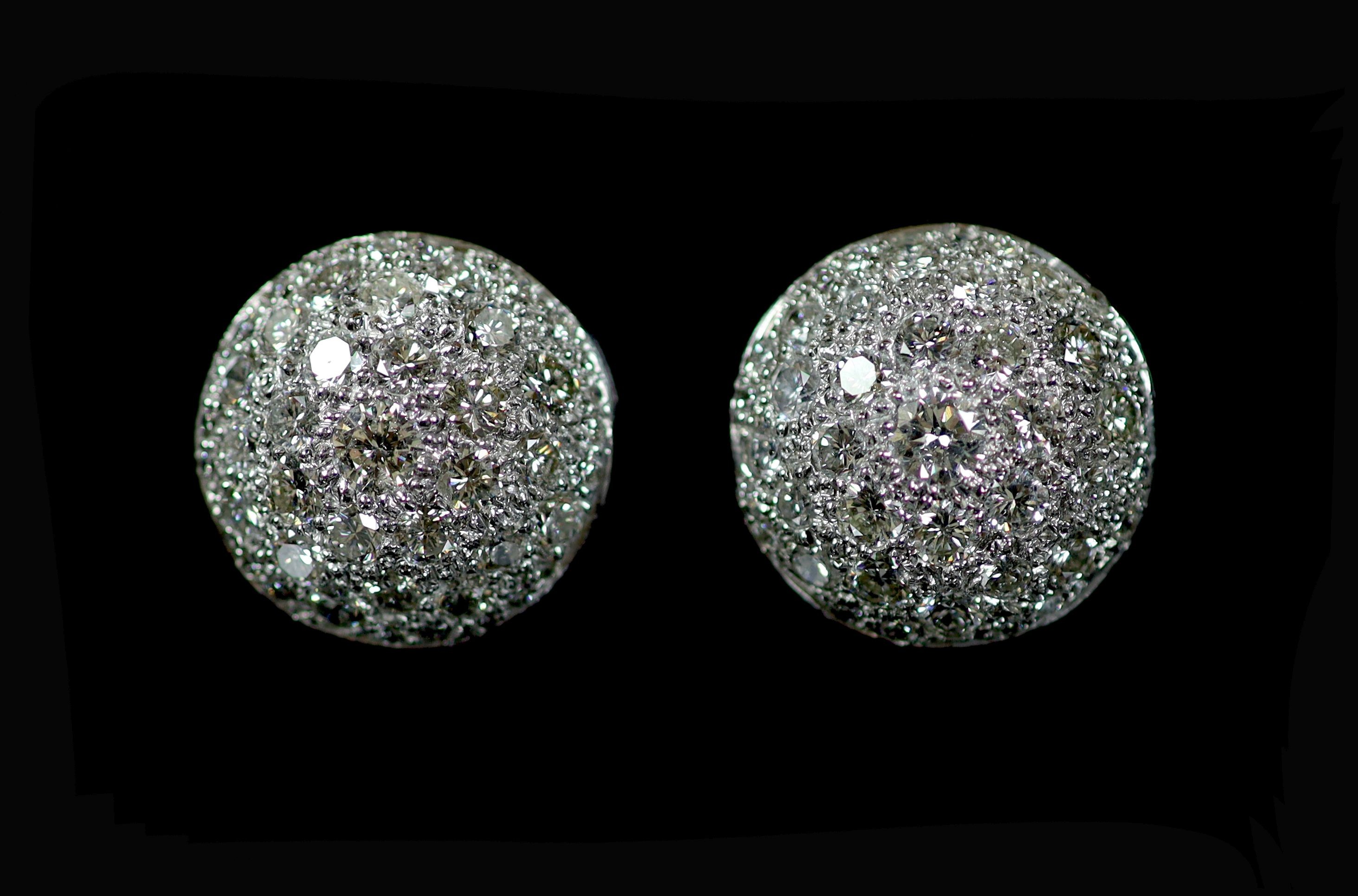 A pair of platinum and pave set diamond set circular domed earrings